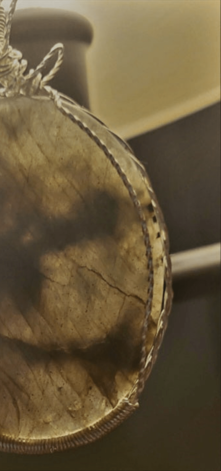 Photo showing labradorite is translucent when held to daylight from light from back of stone